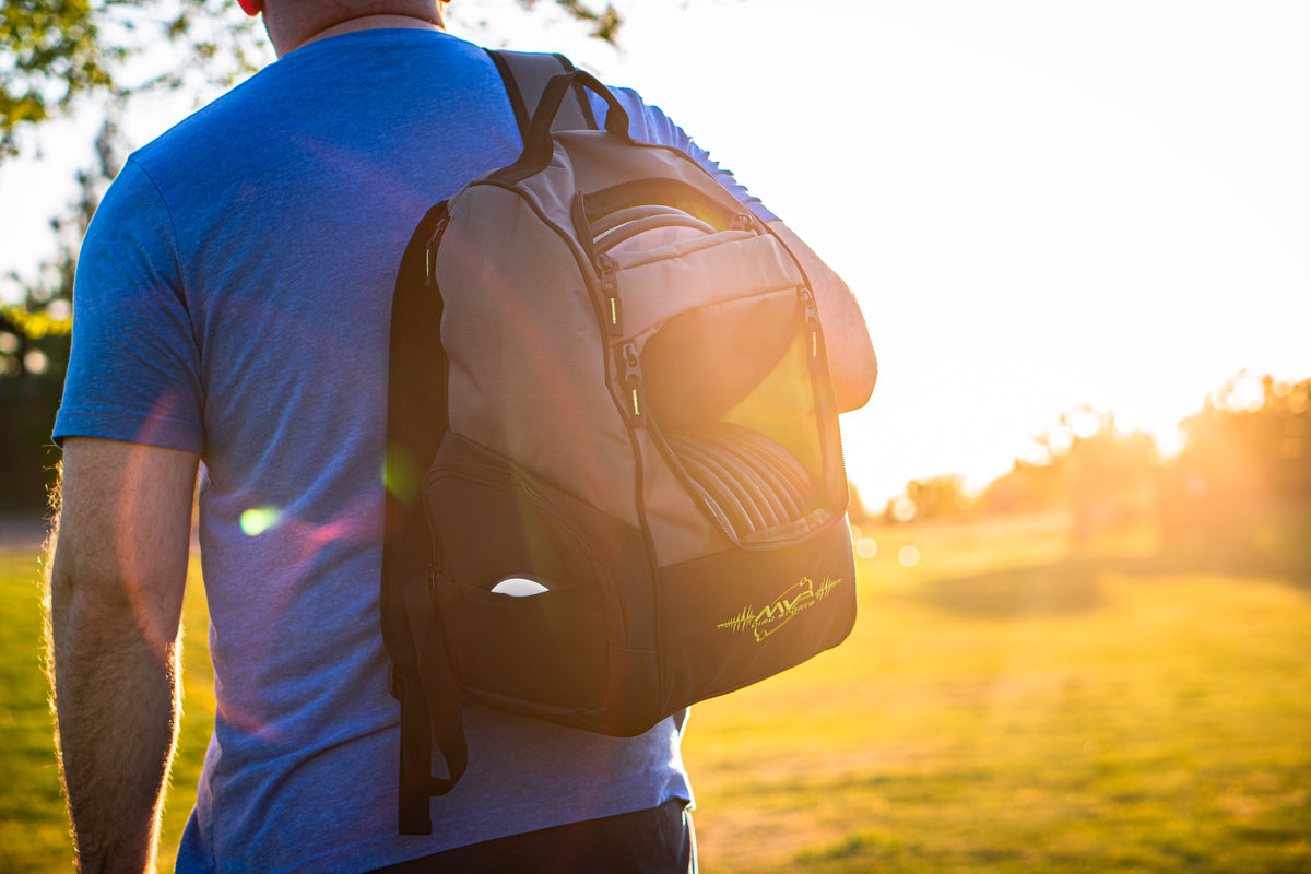 MVP Disc Sports bag worn outdoors with warm sunlight flaring through the open compartment