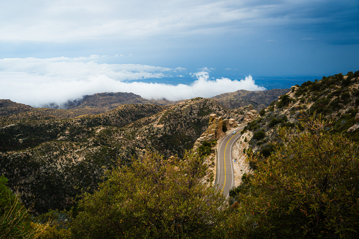 Winding road through the mountains above Tucson beneath dramatic clouds